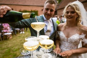 Bruidspaar schenkt champagne tijdens hun huwelijksfeest in de Rupelstreek, vastgelegd door Bart Boodts, huwelijksfotograaf België