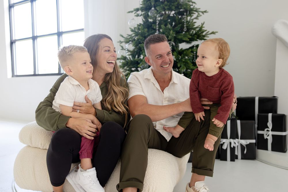 Holiday family photos in modern interior with Christmas tree and white decor.