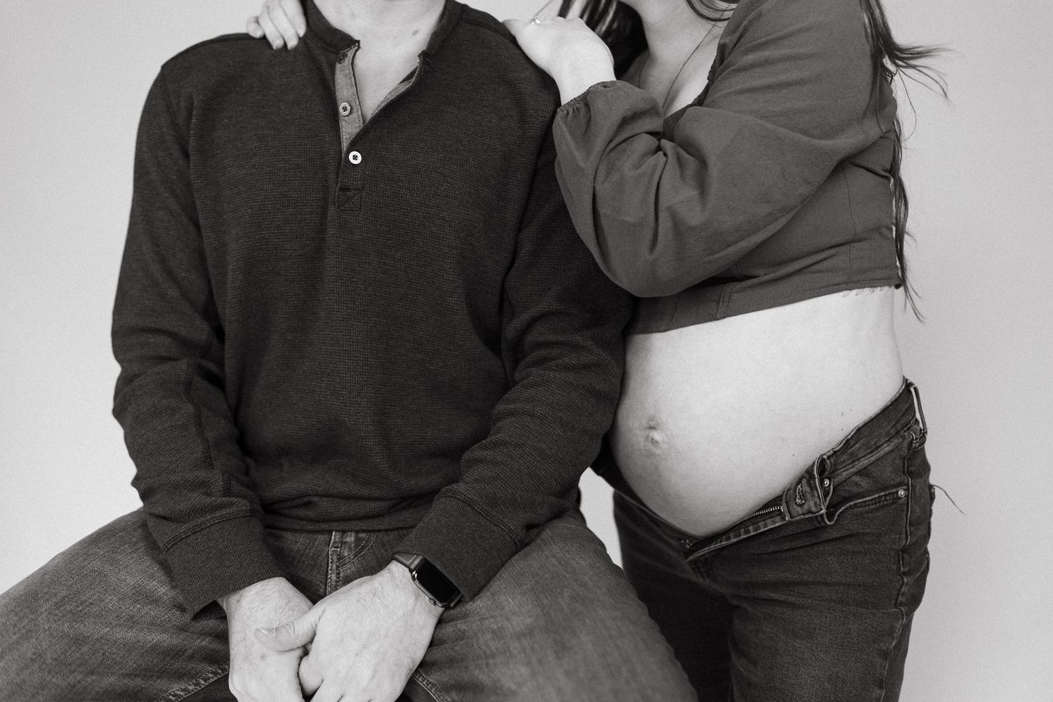Black and white maternity photo showing an intimate moment between expectant parents.
