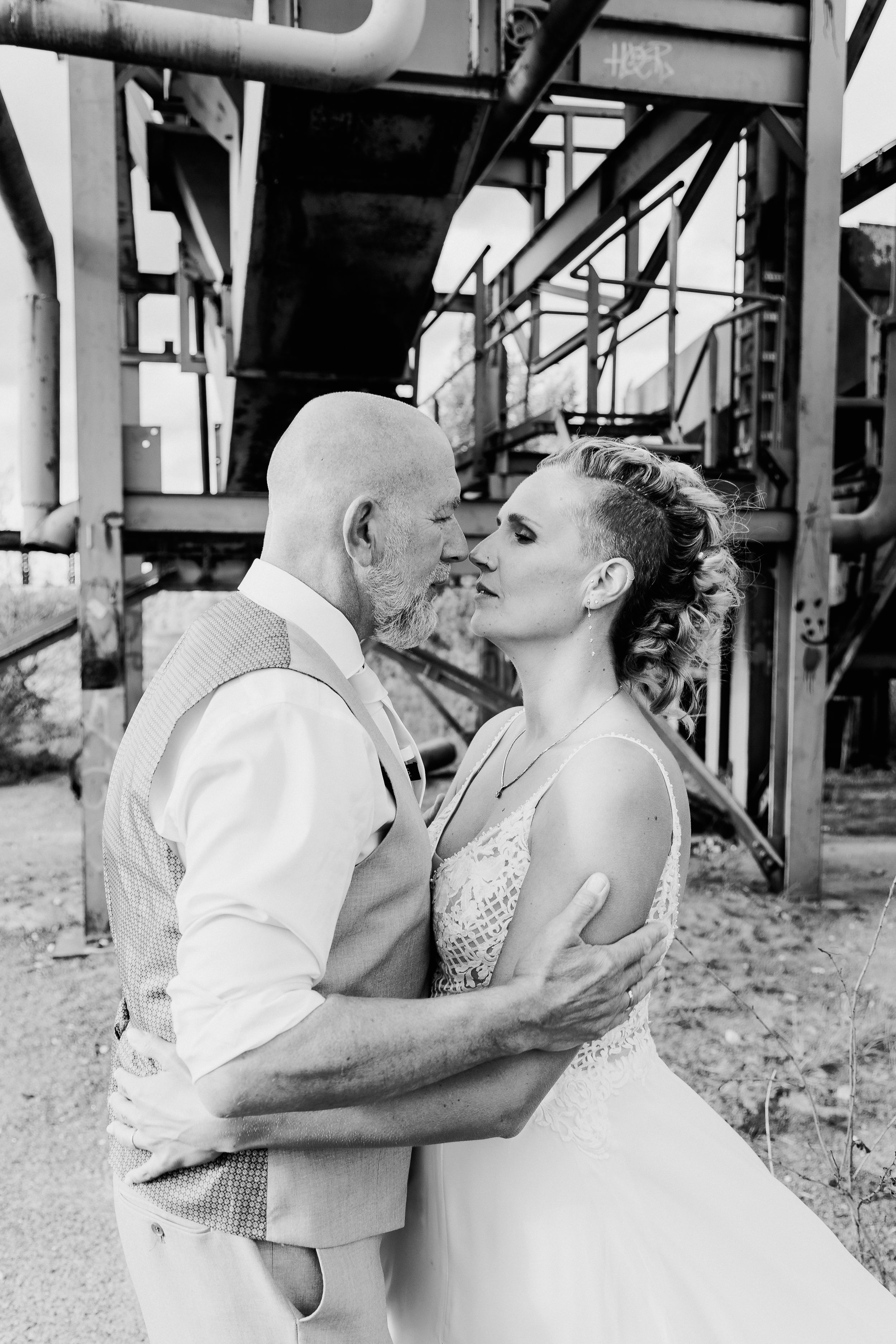 Black and white vintage style romantic couple portraits under industrial architecture.