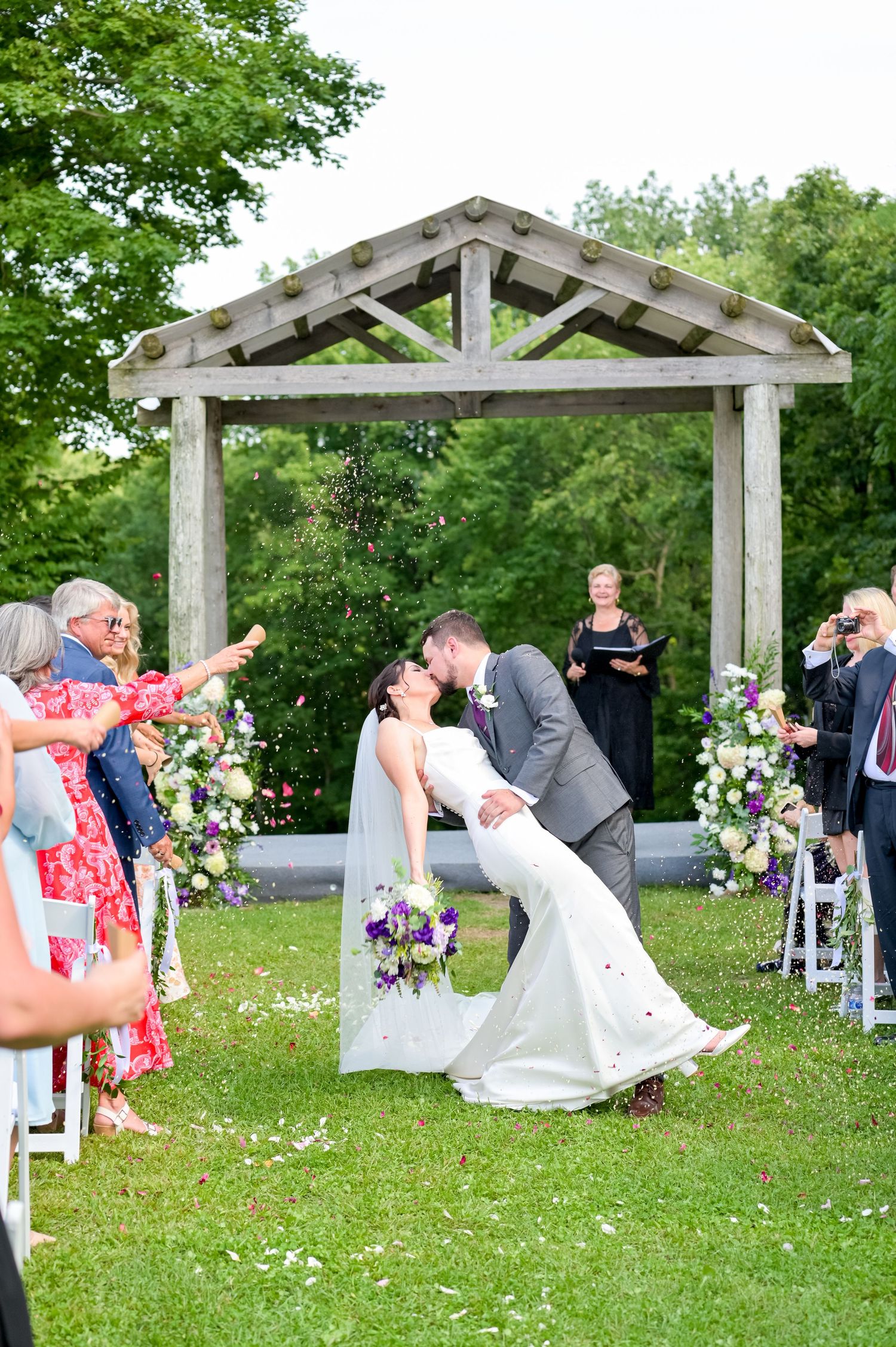 Outdoor wedding ceremony setup with white chairs and floral decorations under a wooden pergola at Boler Mountain in London ontario.
