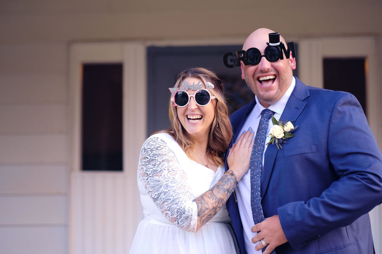 Wedding party members enjoying candid moments and laughter during outdoor celebration.