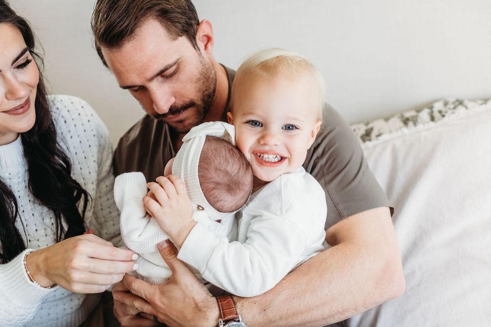 Family enjoying playful moments together on white bedding in New Haven, CT.