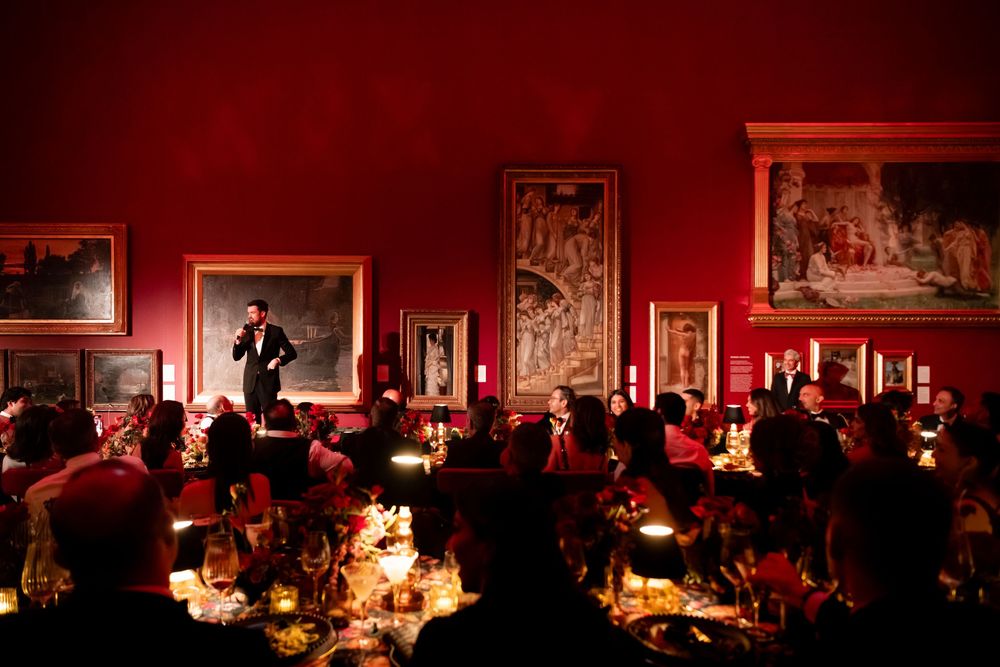 Elegant dining room with red walls and ambient lighting for an evening event.