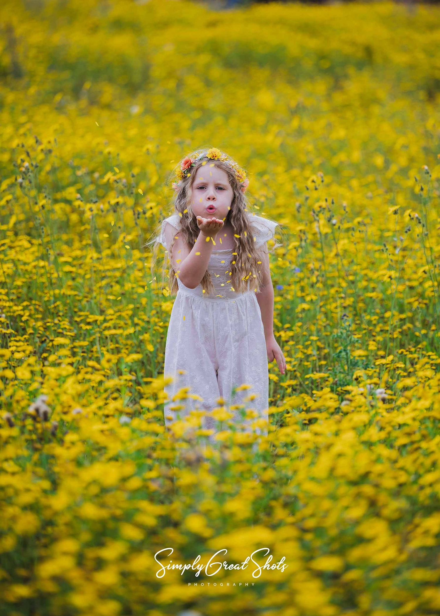 SimplyGreatShots Portrait Photography - A young girl blows flower petals