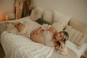 Soft and romantic indoor boudoir session with cream colored textiles and natural light.
