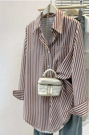 Brown and white striped collared button-down shirt styled with light denim jeans and a small white crossbody bag.