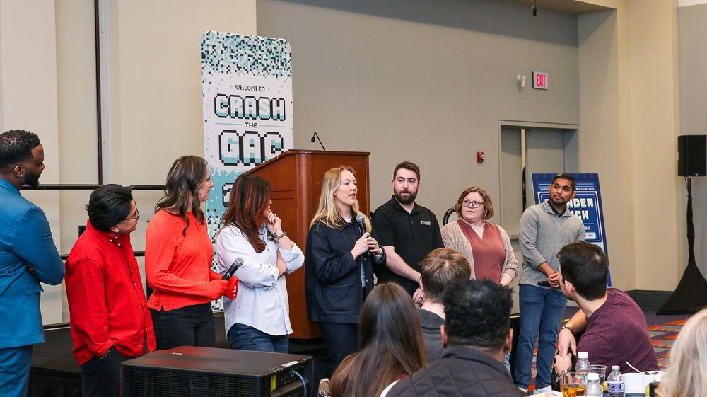 Group of professionals presenting at a Carbon DAC event in a conference room with attendees seated at tables.