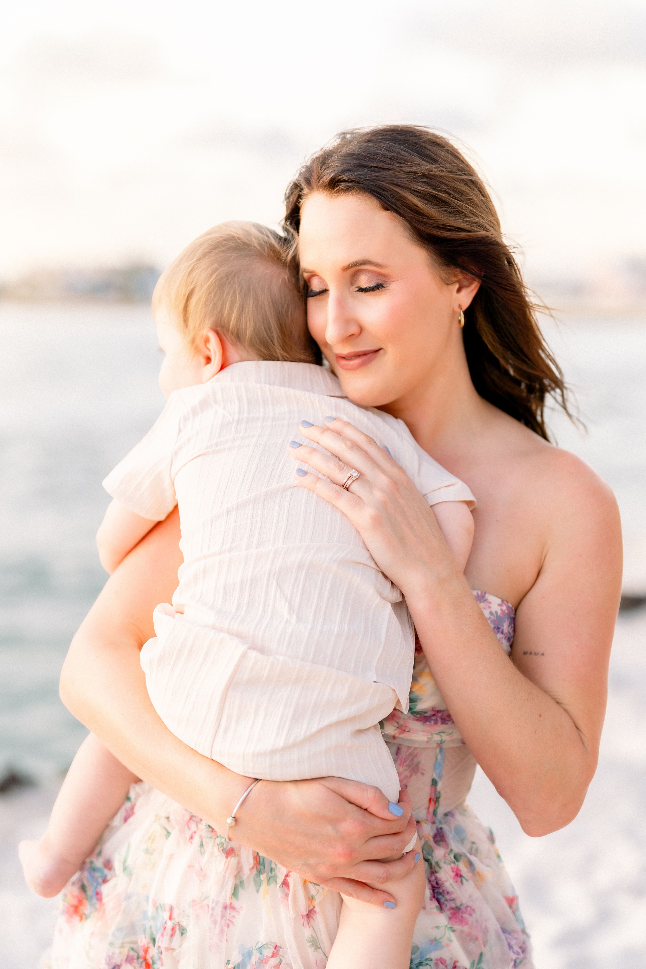 motherhood photoshoot on St. Pete Beach as mother snuggles into her son