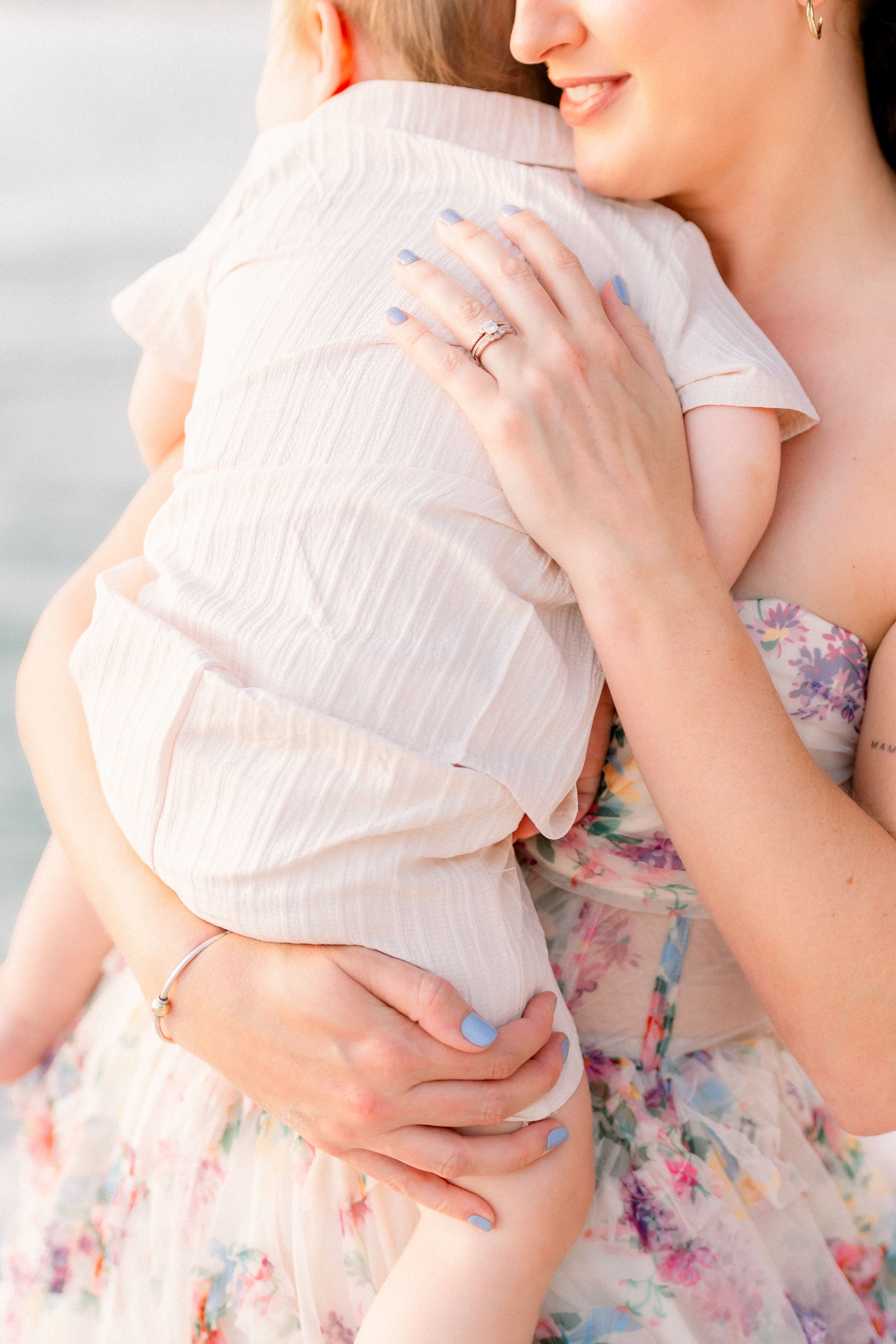 mother rubbing her baby boy's back during a family photoshoot on St. Pete Beach