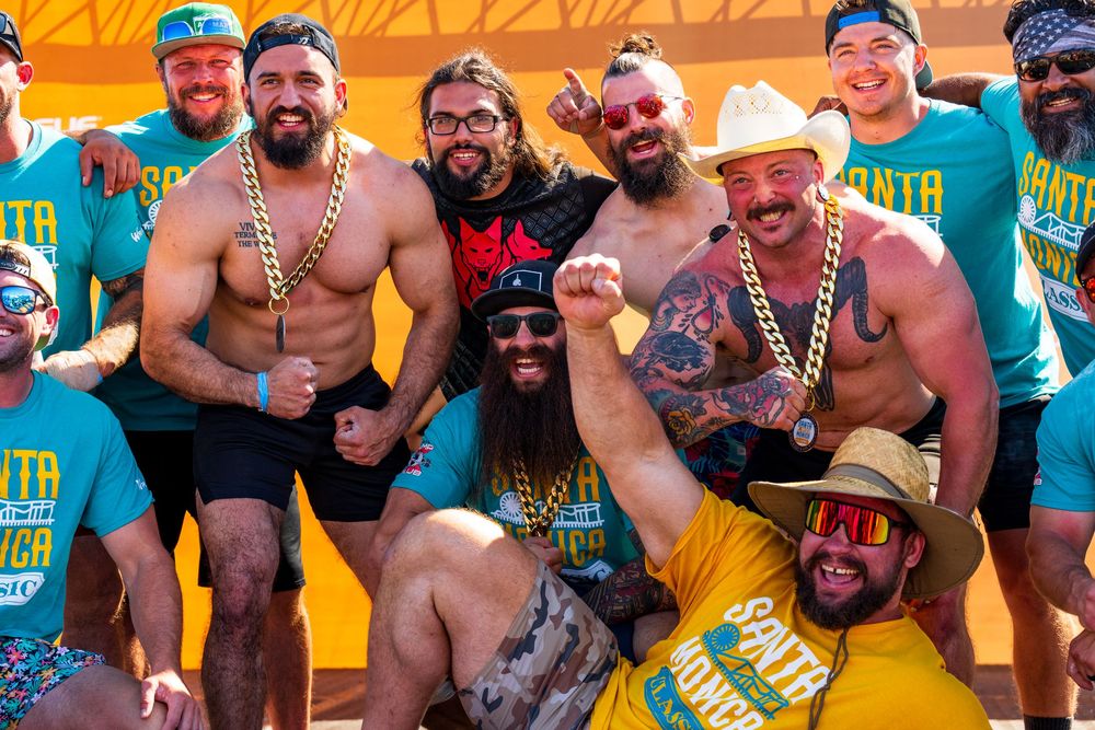 A group of strongmen Santa Monica Strongman's attire celebrate competing with vibrant colors and festive spirit at Santa Monica Pier.