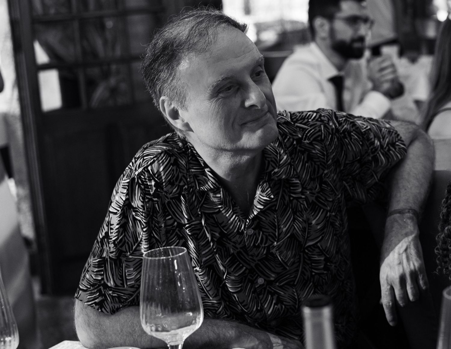 Portrait en noir et blanc d’un invité assis à table pendant le repas de mariage.