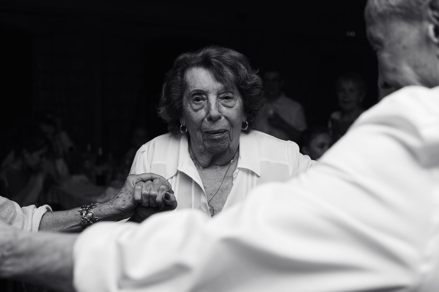 Une invitée danse pendant la soirée de mariage, photographiée en noir et blanc.