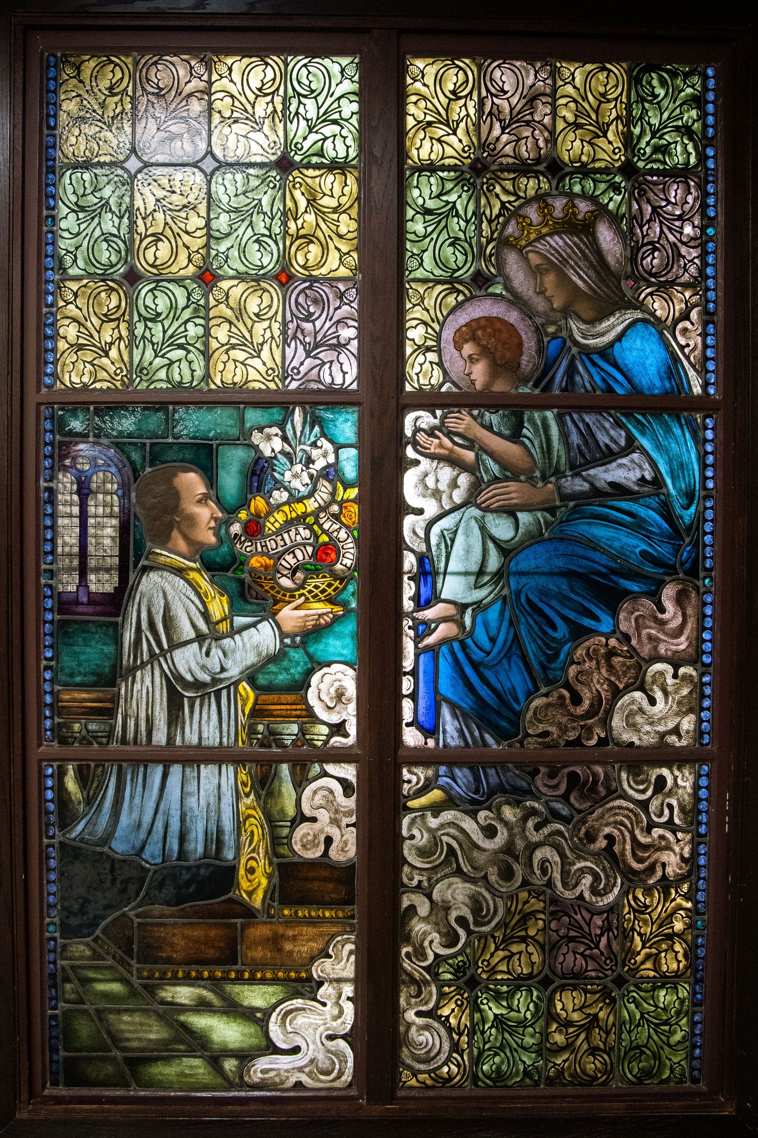 Beautiful stained glass church windows depicting religious scenes in vibrant blues and golds.