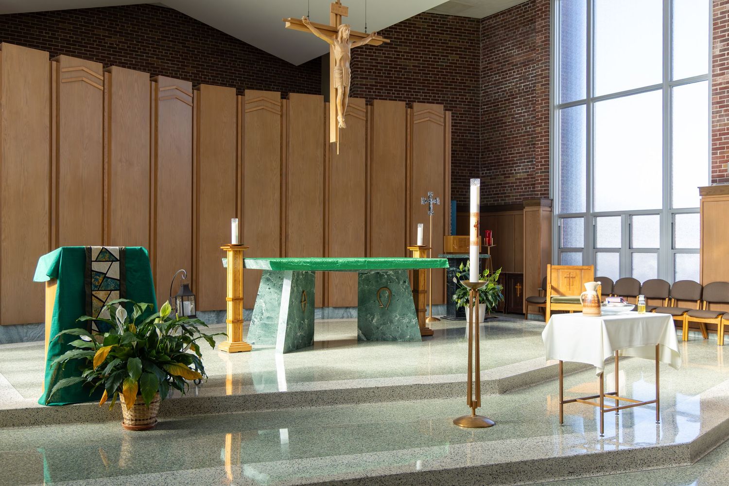 Modern church interior with wooden cross, large windows, and simple contemporary design features natural lighting.