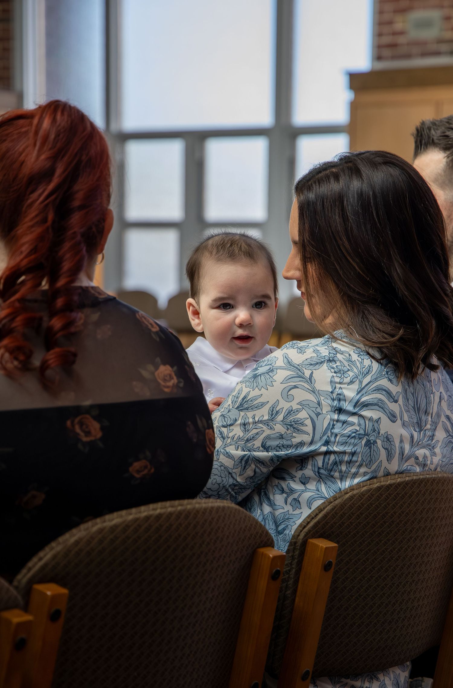 A sequence of images showing a baby peeking over the back of a chair in a room with windows.