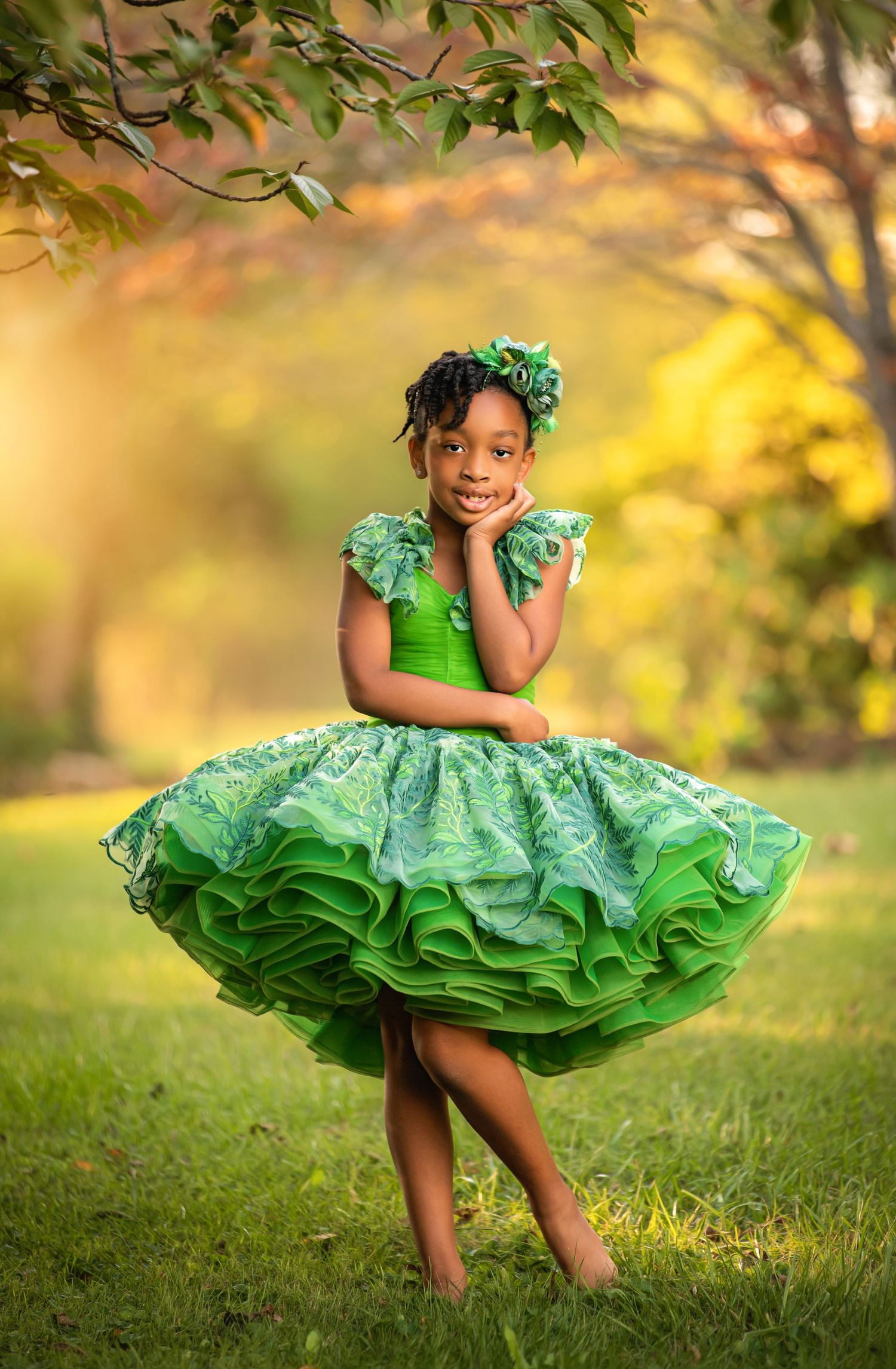 A flowing olive green dress twirls gracefully in an enchanted autumn forest setting with golden sunlight.