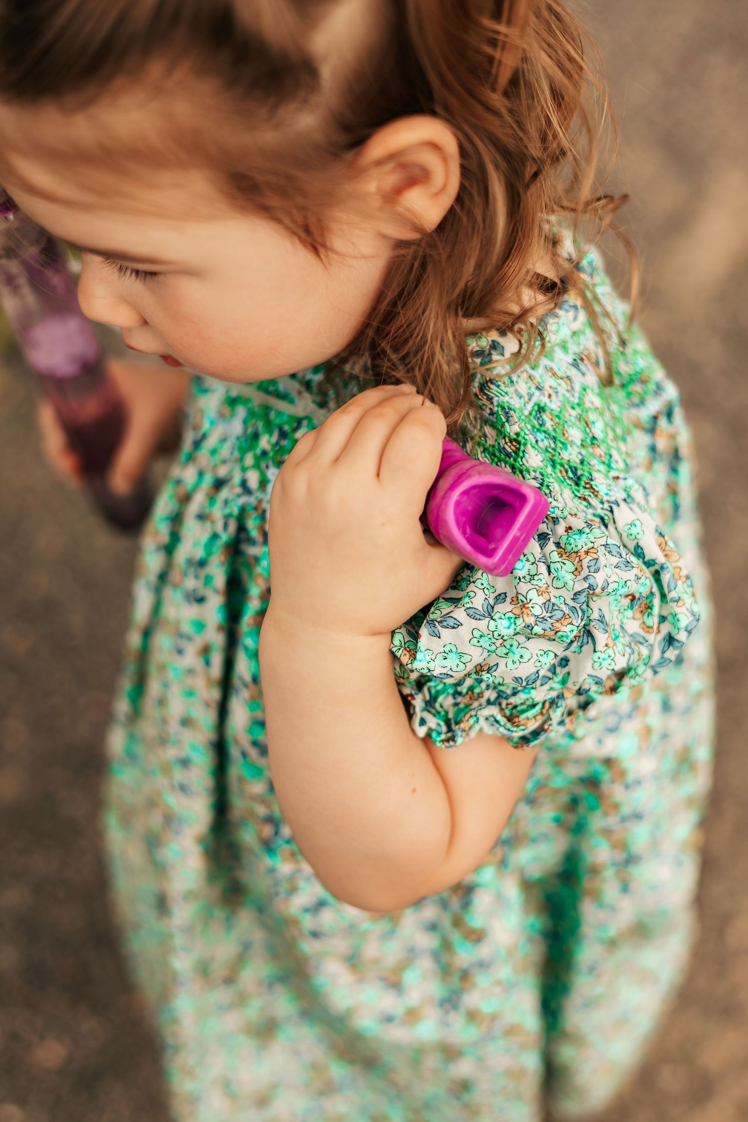 Young girl in floral green dress  holding purple bubble container| Boulder Family Photographer