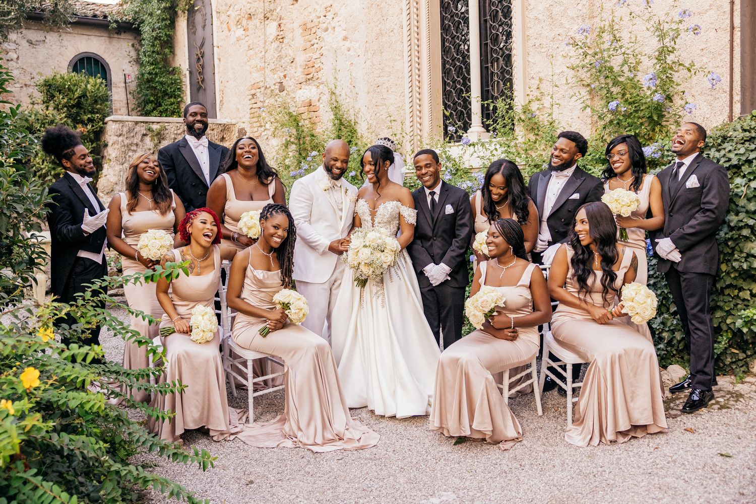 Bride and groom walking in the gardens of Isola del Garda accompanied by a roaming band