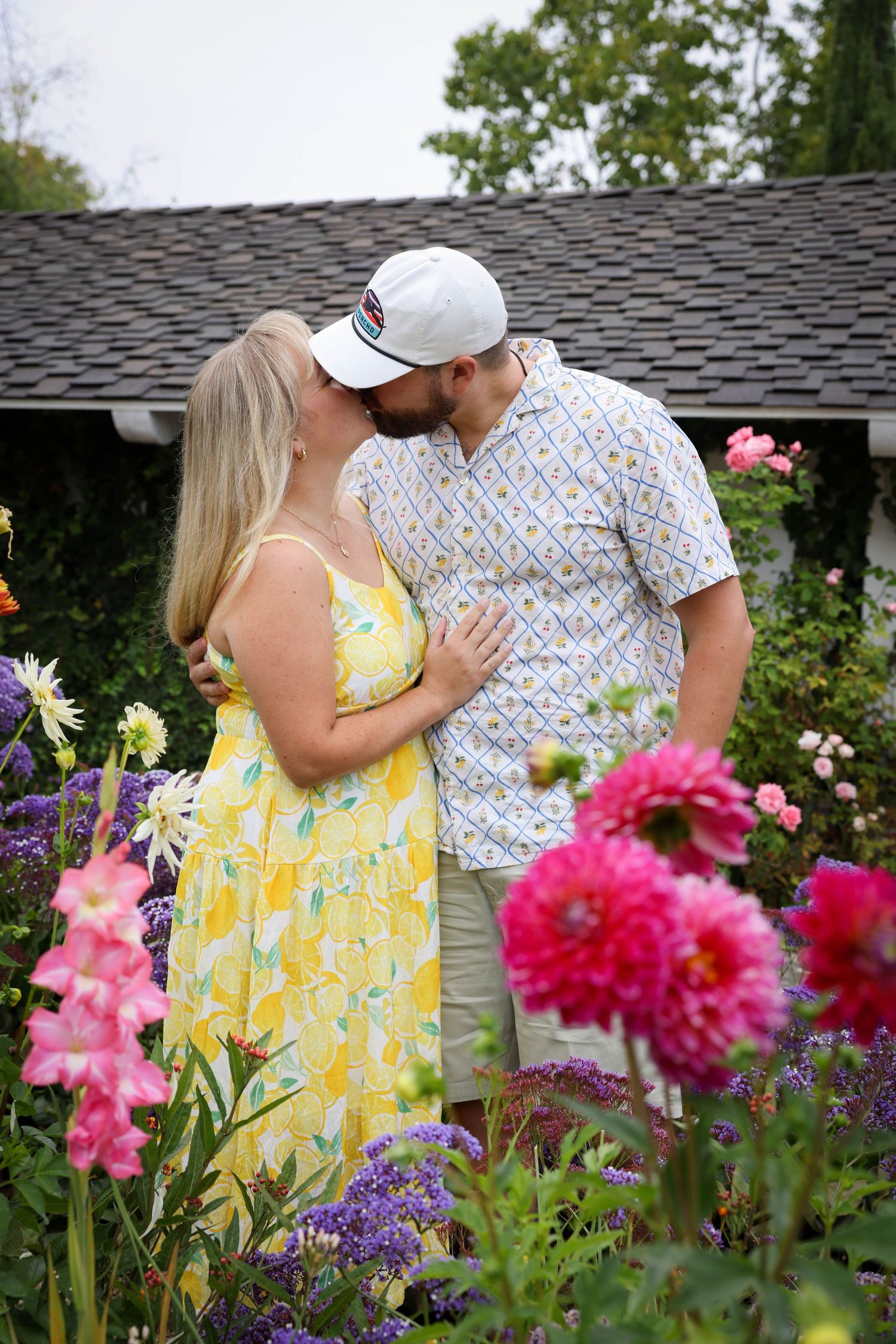 Couple shares a kiss amongst the flowers in the Secret Garden at the Madonna Inn in San Luis Obispo