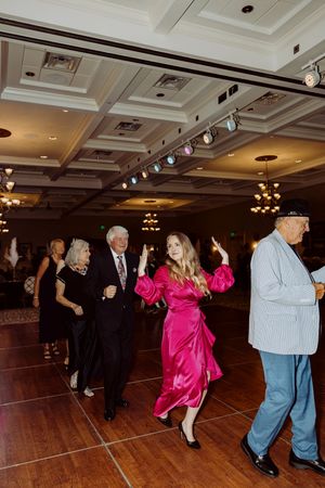 Guests in formal and festive attire dance on the ballroom floor at an elegant gala.