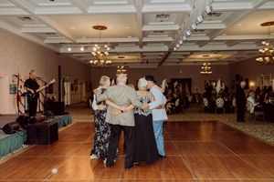 Elderly guests enjoy a group dance on the ballroom floor at an elegant formal gala event.