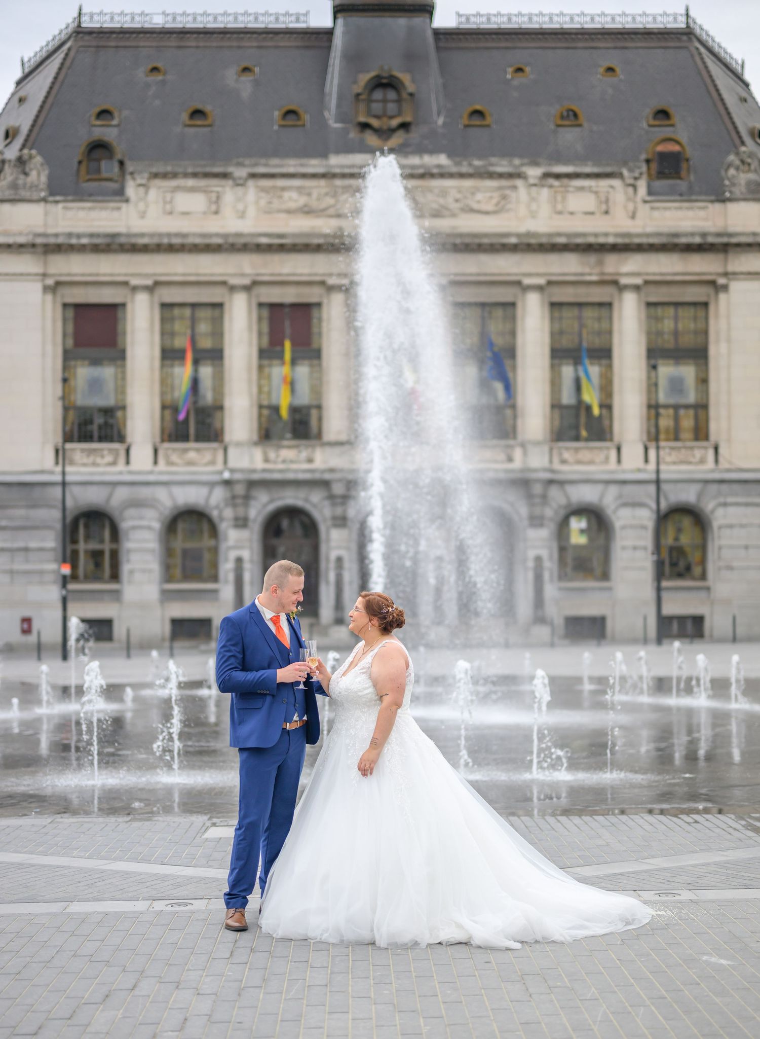 A romantic wedding couple poses in a series of elegant shots under stone archways at a historic European castle.