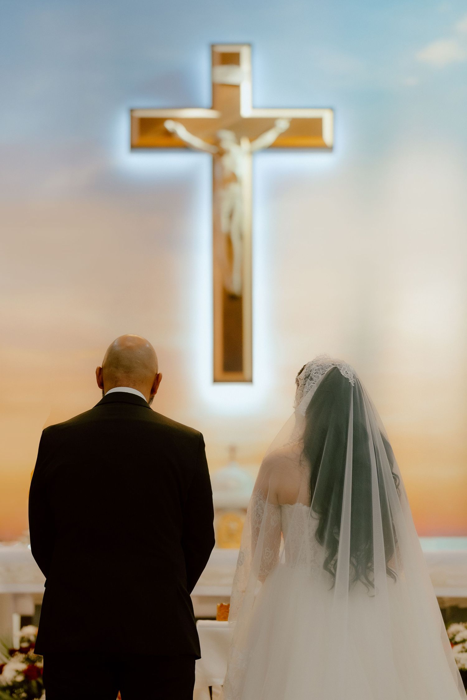Bride and groom standing before the altar cross during a wedding ceremony in Dubai