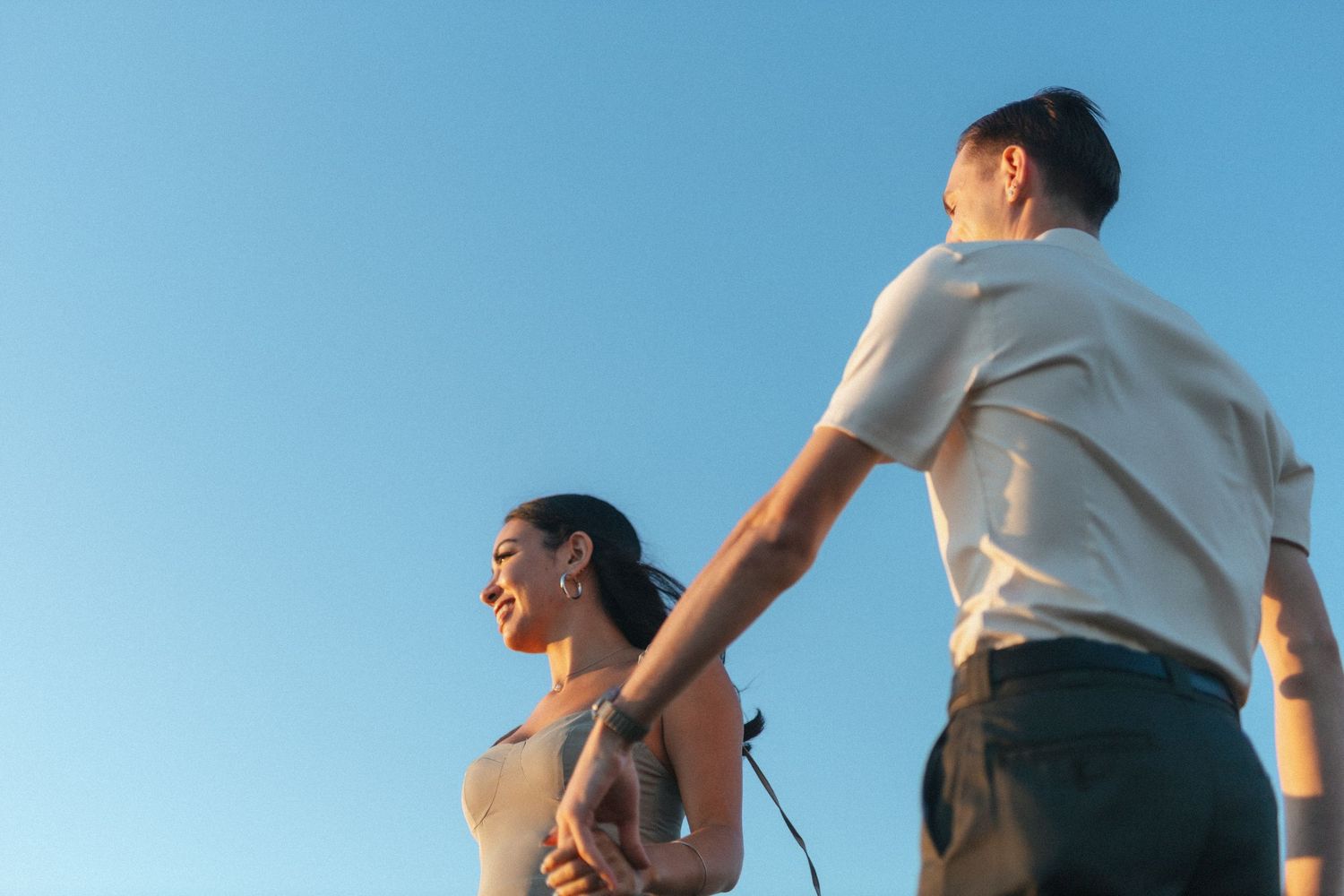 bride and groom spin around against a bright blue sky during Vancouver Island Elopement