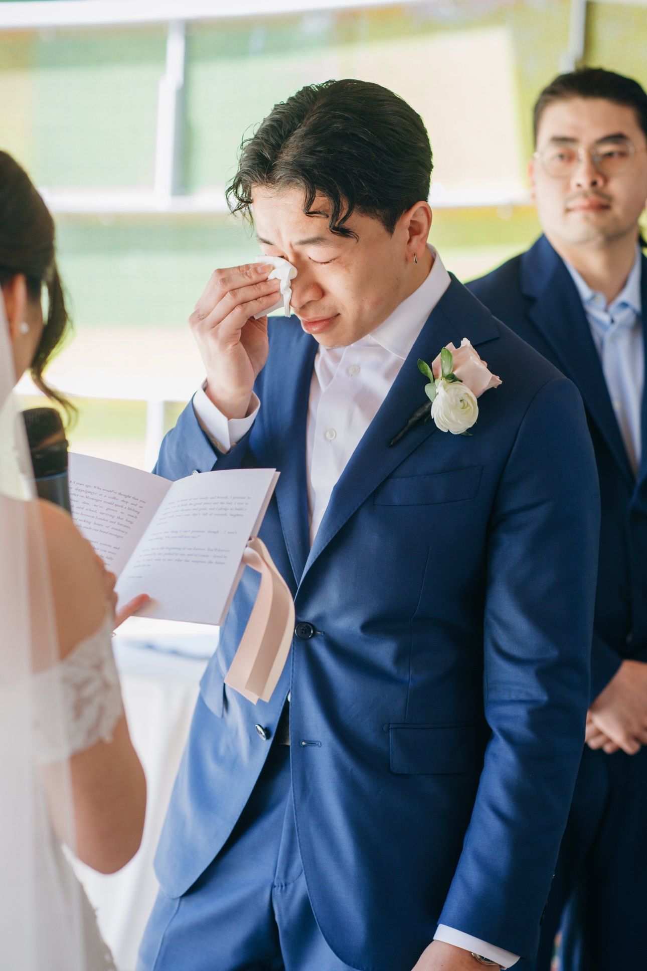 Groom wiping away tears during his wedding vows at Celebration Pavilion in Queen Elizabeth Park, Vancouver