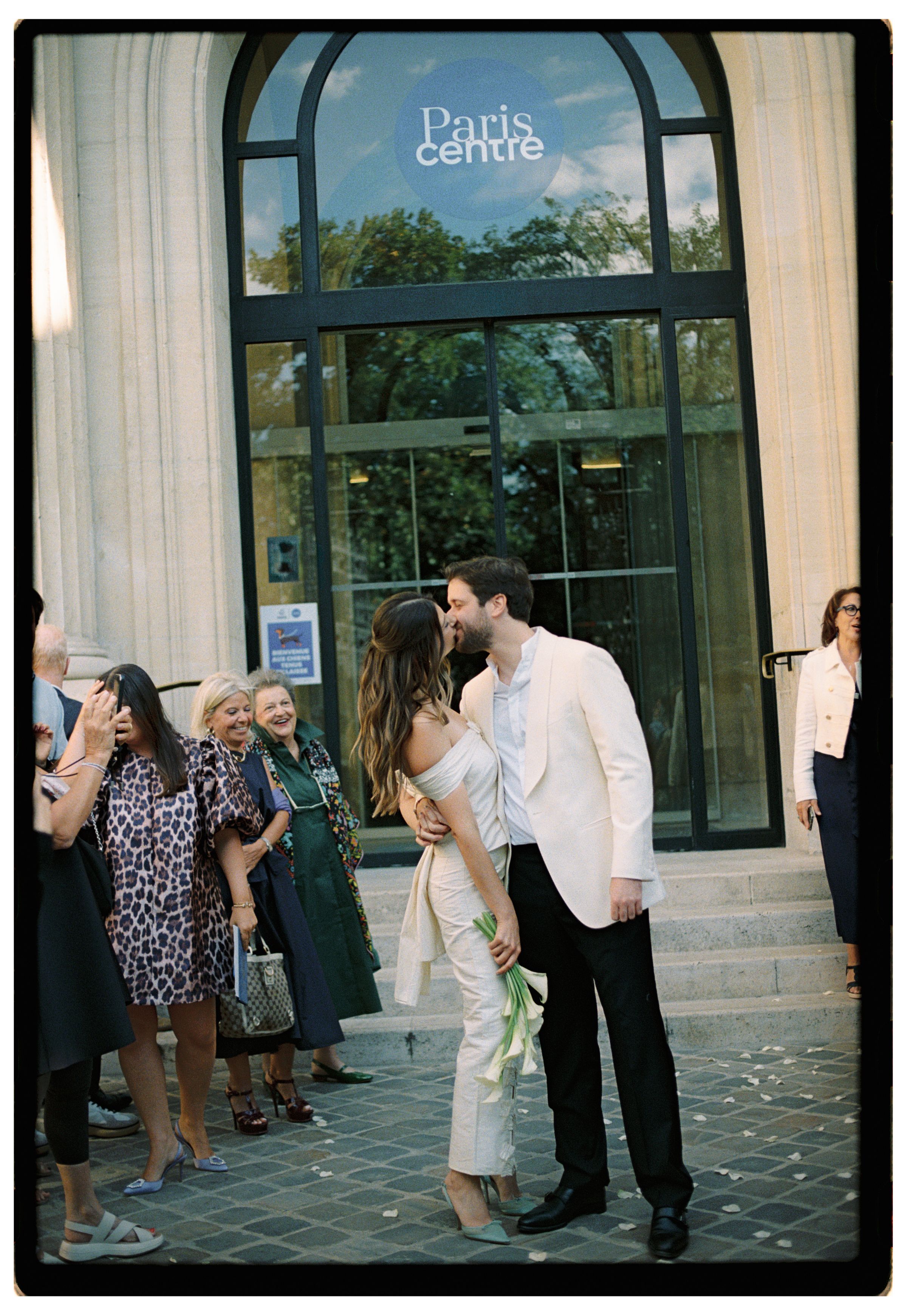 Couple sharing a kiss outside Paris Centre building after their wedding ceremony. paris civil wedding photographer. paris film photos
