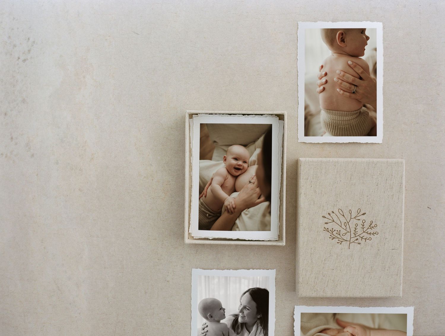 A gallery wall display of family photos featuring a smiling baby, mother and child, and newborn details in neutral frames.