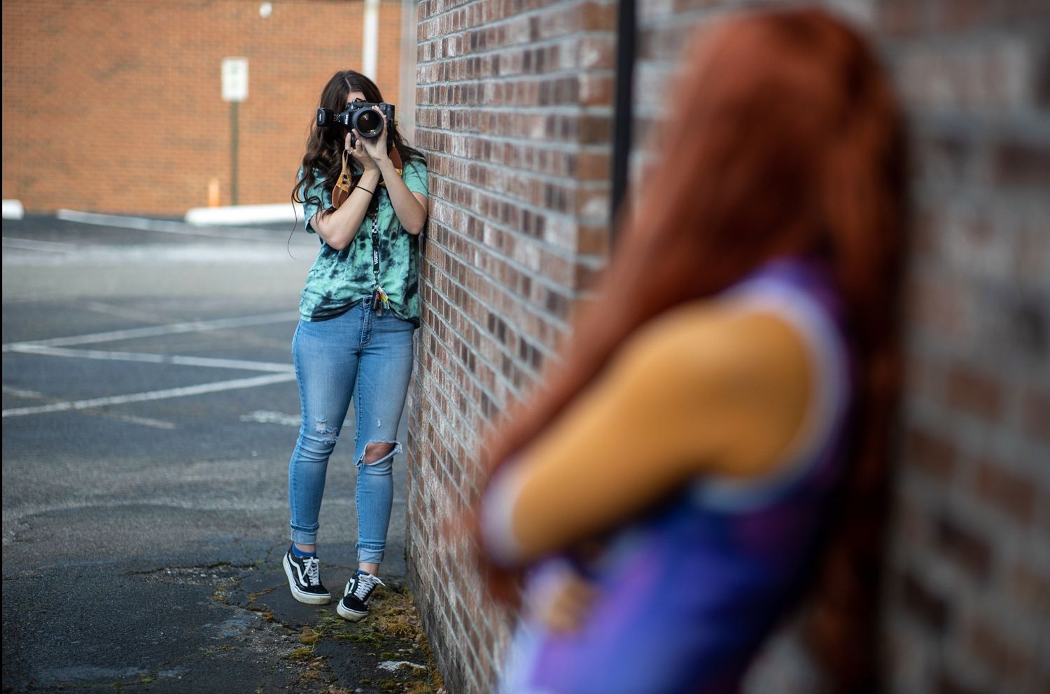 Behind the scenes of photographer Ella Monroe of Ella Monroe Photography capturing a creative portrait session along a brick wall in Rome, G