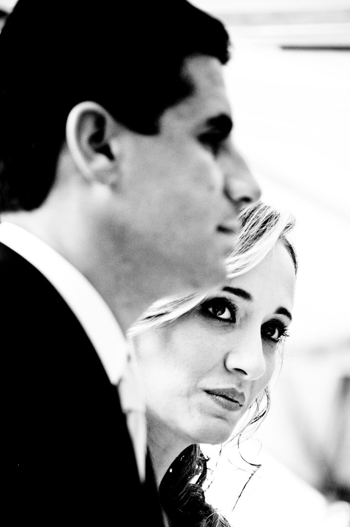 Black and white portrait of a blonde woman and dark-haired man in formal attire, captured in dramatic close-up profile.