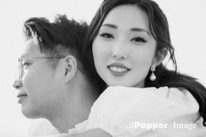 Black and white portrait of a smiling Asian couple posing together in a professional photo shoot.
