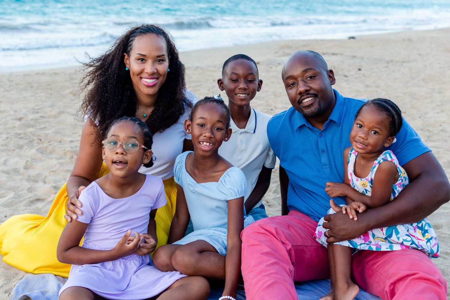 Family portrait. Mom, dad, and four kids seated on the beach in Isla Verde, Carolina, Puerto Rico.