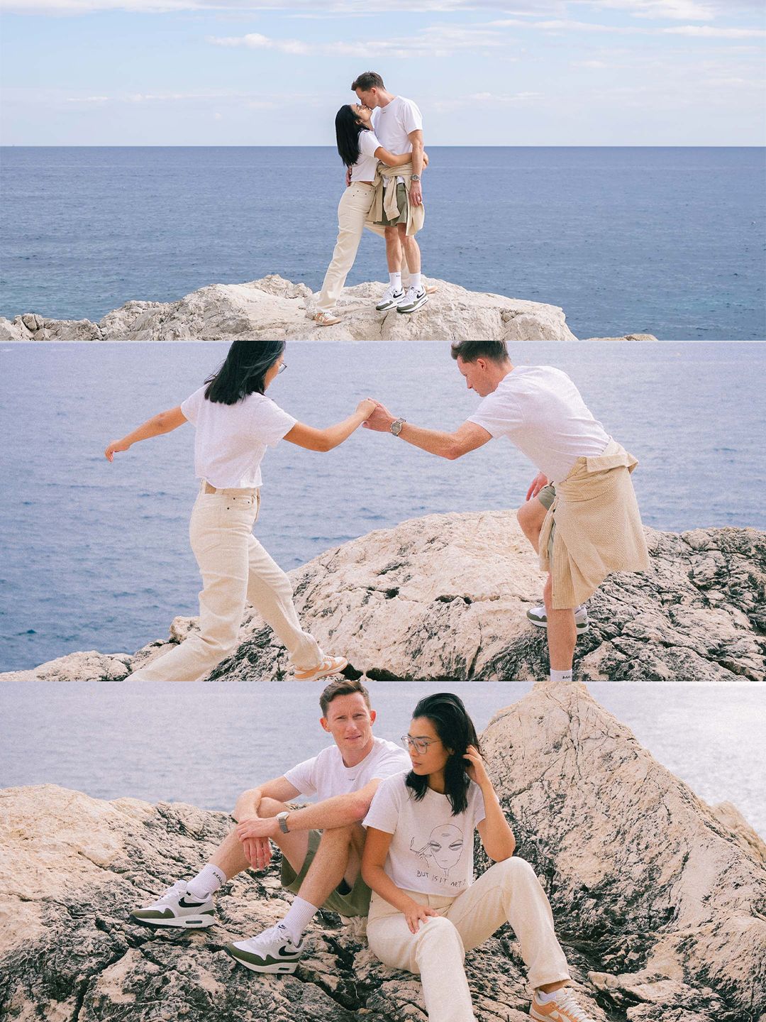 Couple posing playfully on seaside rocks, holding hands and sitting together with blue ocean backdrop.