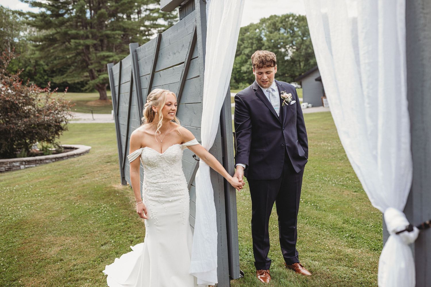 couple doing first touch without seeing each other at their skowhegan maine venue, waters edge estate captured by maine wedding photographer