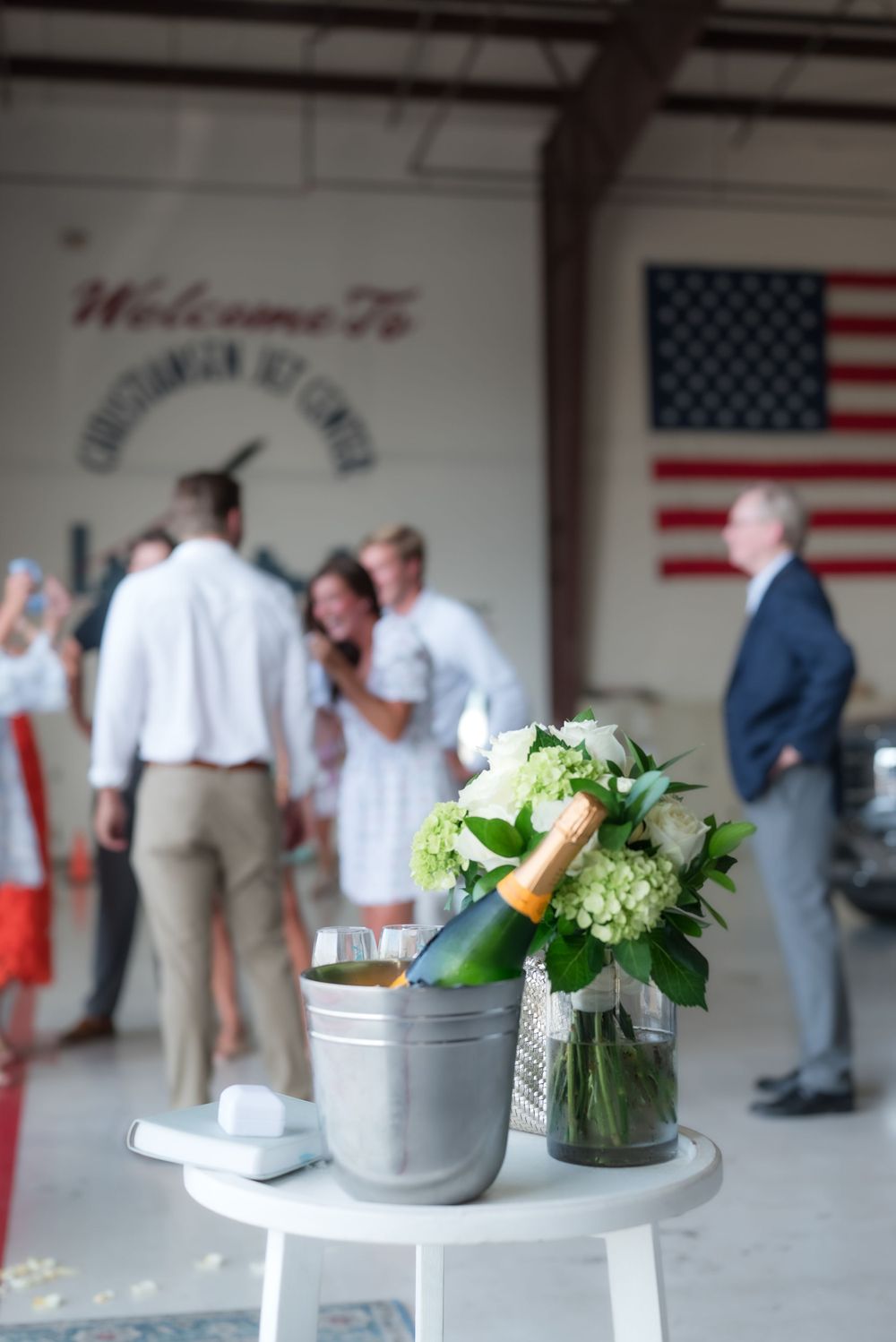 Floral arrangements and champagne set up for celebration at an aviation center.