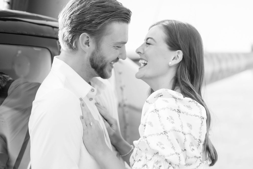 A black and white portrait of a couple sharing an intimate moment outdoors.