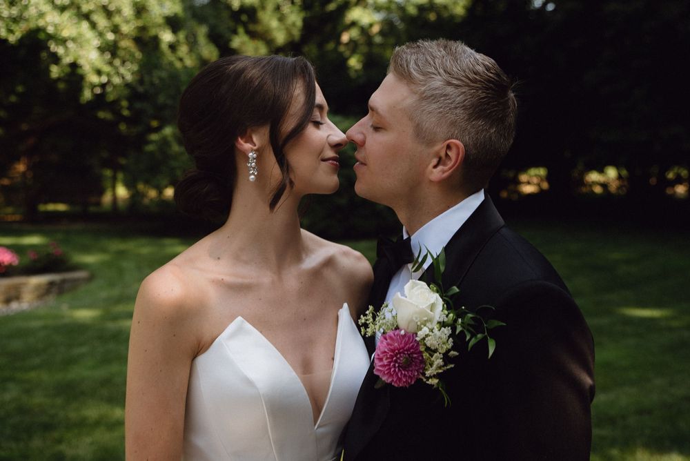 Romantic wedding portrait of couple sharing intimate moment in garden setting.