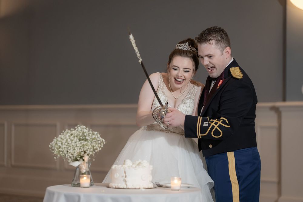 Bride and groom cutting their wedding cake with a sword at The Galliard Center in Charleston, SC
