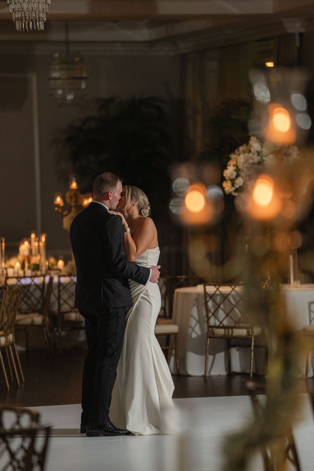 Bride and groom kissing in low light on the dance floor at Pelican Club in Jupiter, FL