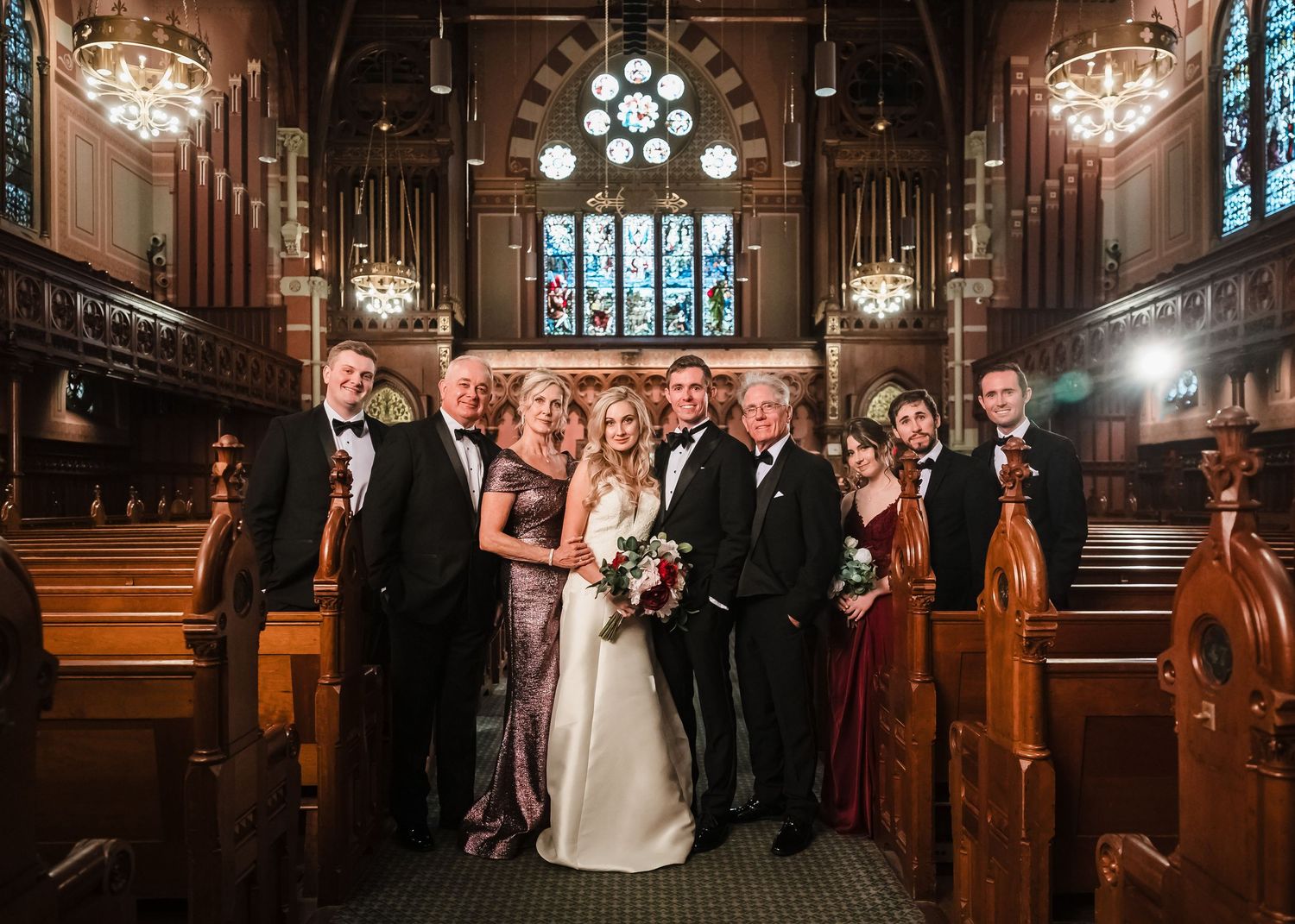 Bride and groom with family standing in the wooden pews of Old South Church in Boston, formal black tie attire.