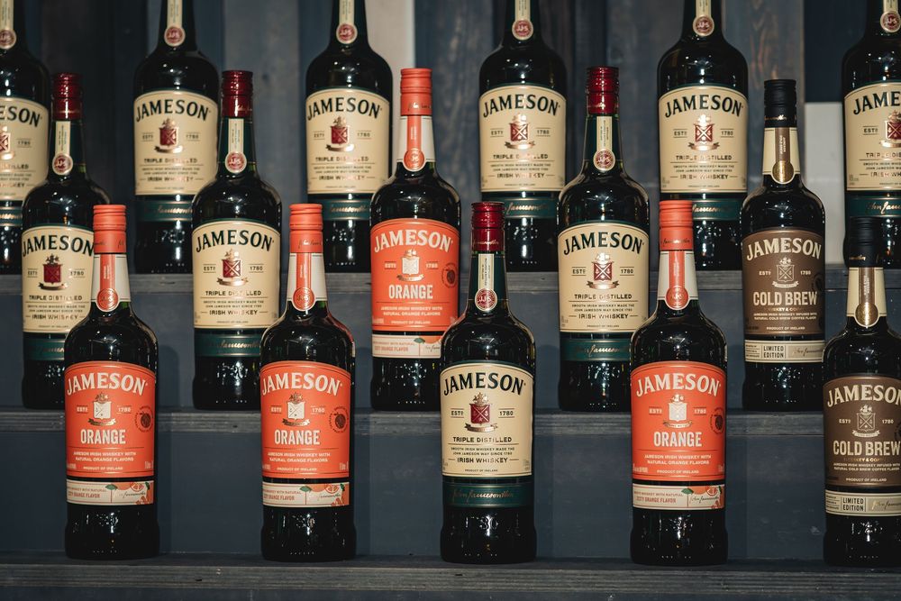 Multiple Jameson Irish Whiskey bottles including Orange and Cold Brew varieties displayed on shelves.