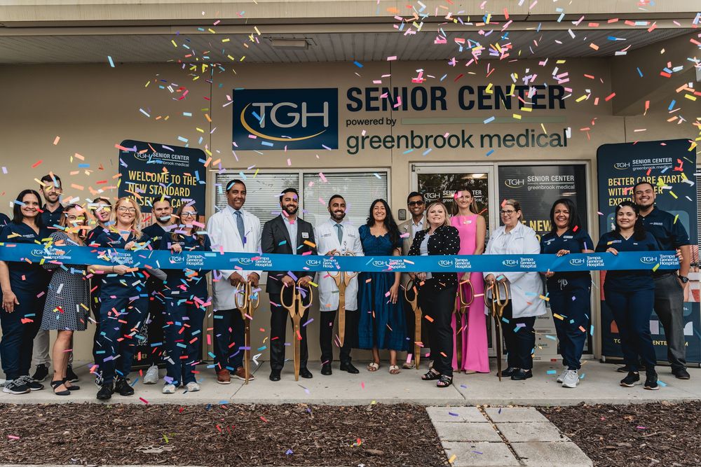 TGH Senior Center ribbon cutting ceremony with staff celebrating grand opening with confetti.