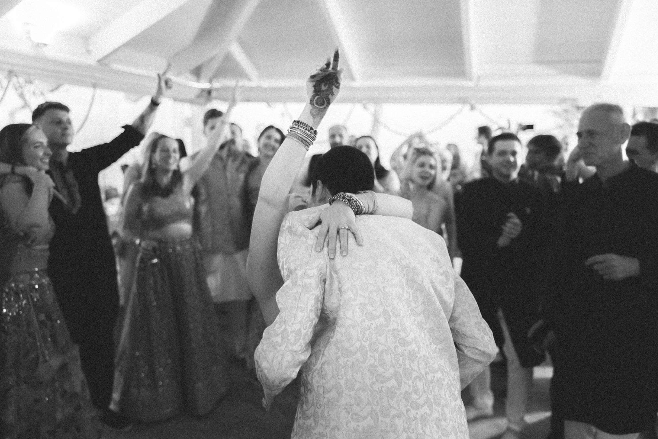 Emotional black and white photograph of the bride and groom embracing during the wedding reception at Arriba by the Sea overlooking the Atla