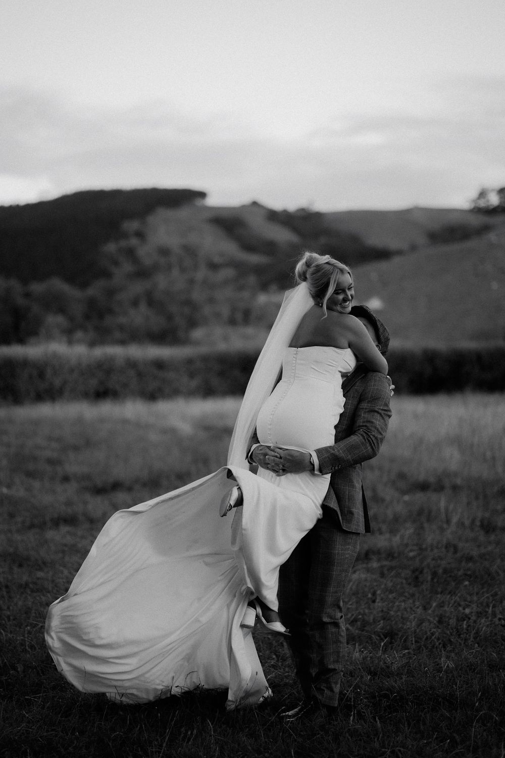 A series of romantic dance poses captured in black and white against a rolling hillside landscape.