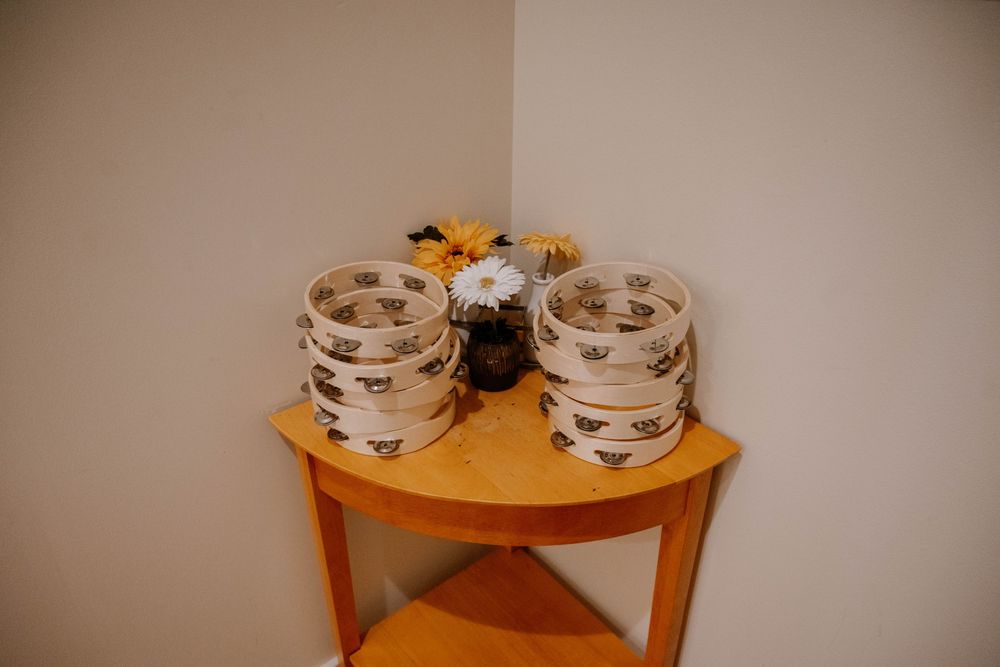 Stacked ceramic bee-print bowls on a wooden corner shelf with yellow and white flowers.