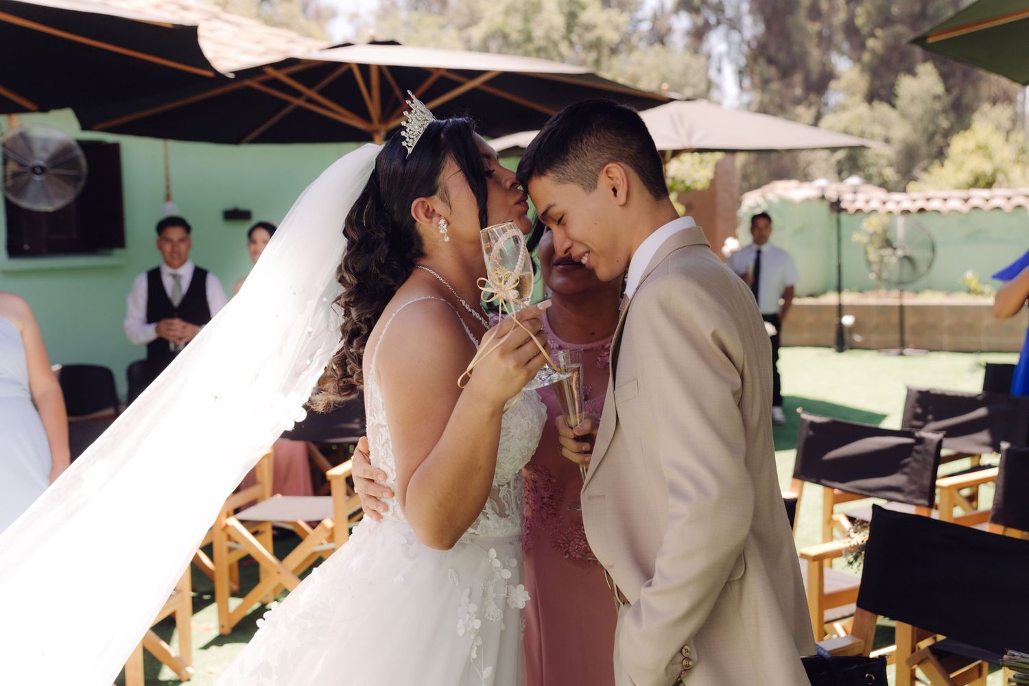 Bride and groom share intimate champagne toast moment at outdoor wedding reception.
